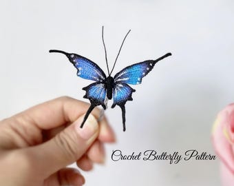 May include: A crocheted butterfly with blue and black wings. The butterfly has delicate details and long antennae. The text "Crochet Butterfly Pattern" is written in cursive below the butterfly.