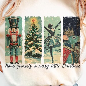 Peut inclure: T-shirt crème avec un motif de Noël de style vintage. Le graphisme comprend un casse-noisette, un sapin de Noël, une ballerine et un roi des souris, avec le texte "Have yourself a merry little Christmas".