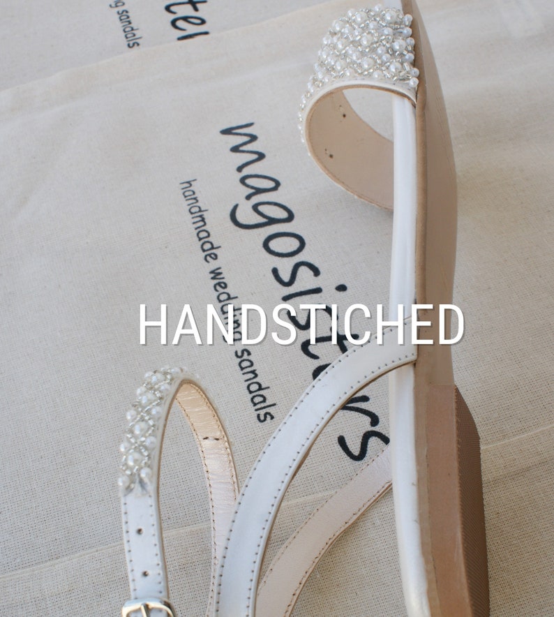 May include: White leather sandals with pearl embellishments. The sandals have a simple design with three straps and a buckle closure. The text "HANDSTITCHED" and "magosilvers" is visible on the sandals.