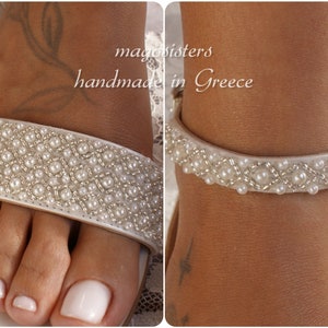 May include: White sandals with a pearl and silver beaded strap. The sandals are handmade in Greece.