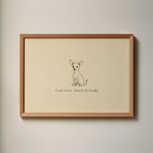 May include: A framed print featuring a minimalist line drawing of a Chihuahua. The artwork is set against a cream-colored background, with the text "Cute Face. Sharp Attitude." printed below the dog illustration. The frame is made of light brown wood.