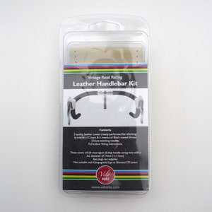 May include: Vintage Road Racing Leather Handlebar Kit packaging with two tan leather handlebar covers, black waxed thread, and needles.  The kit includes instructions for installing the covers on a drop handlebar.