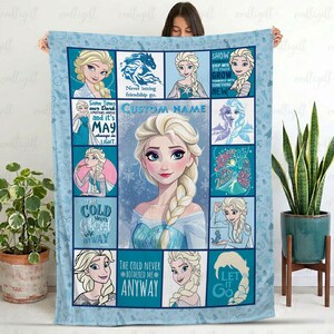 May include: A light blue fleece blanket featuring a collage of Elsa from Frozen, including multiple illustrations of the character with her signature blonde braid, snowflake patterns, and inspirational quotes like The cold never bothered me anyway.