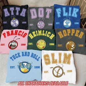 May include: A set of ten colorful t-shirts featuring characters from the animated film A Bug's Life. Each shirt has a different character's name and a cartoon image of the character. The shirts are all in a college-style design with the text "EST. 1998" on each shirt.