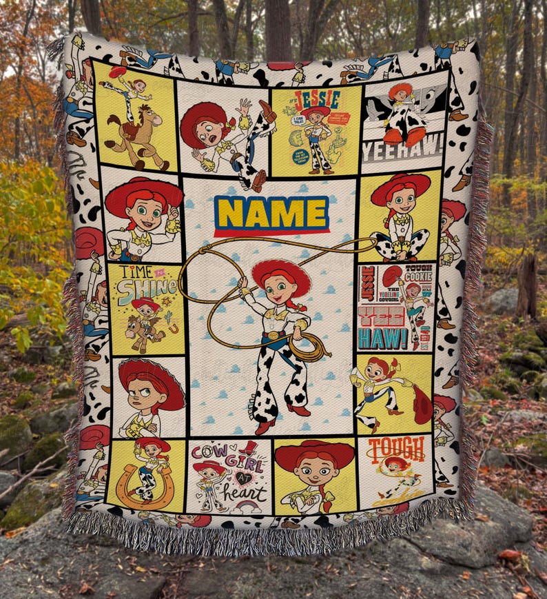 May include: A woven throw blanket featuring a collage of Jessie the Cowgirl from Toy Story in various poses, including lassoing, with the text "NAME", "TIME TO SHINE", "YEEHAW", "COWGIRL AT HEART", and "TOUGH COOKIE" printed on a cream background.