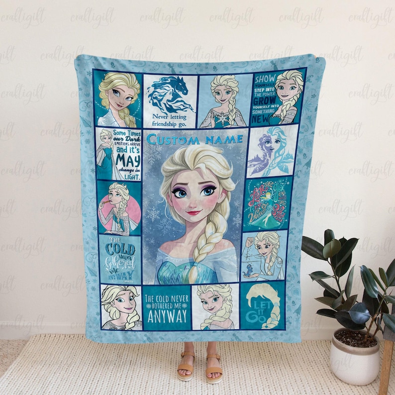 May include: A light blue fleece blanket featuring a collage of Elsa from Frozen, including multiple illustrations of the character, snowflake patterns, and text such as "The cold never bothered me anyway" and "Show yourself into the power".