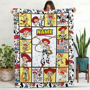 May include: A rectangular fleece blanket featuring a collage of Jessie the cowgirl from Toy Story in various poses. The design includes yellow and white panels with the text NAME, YEEHAW, TIME TO SHINE, COW GIRL AT HEART, and TOUGH COOKIE.