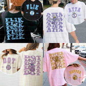 May include: Collection of graphic t-shirts featuring characters and text from a movie. Designs include "FLIK", "ATTA", "DOT", and "HOPPER" with accompanying illustrations and the year "1998" or "1990". The shirts are in various colors.