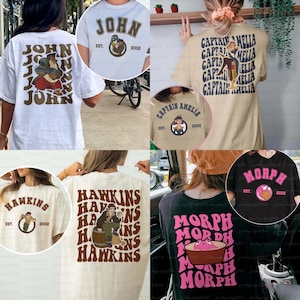 May include: Several t-shirts in white and beige, each with a unique graphic. One has "JOHN" in brown, another "CAPTAIN AMELIA", and a third "HAWKINS". A black t-shirt displays "MORPH". All shirts have a vintage aesthetic.