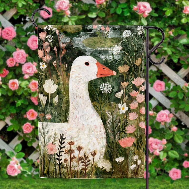 May include: A garden flag featuring a white goose with an orange beak, set against a backdrop of lush greenery and pink and white flowers. The artwork has a painterly style, with visible brushstrokes. The flag is displayed on a black metal stand, perfect for outdoor decor.