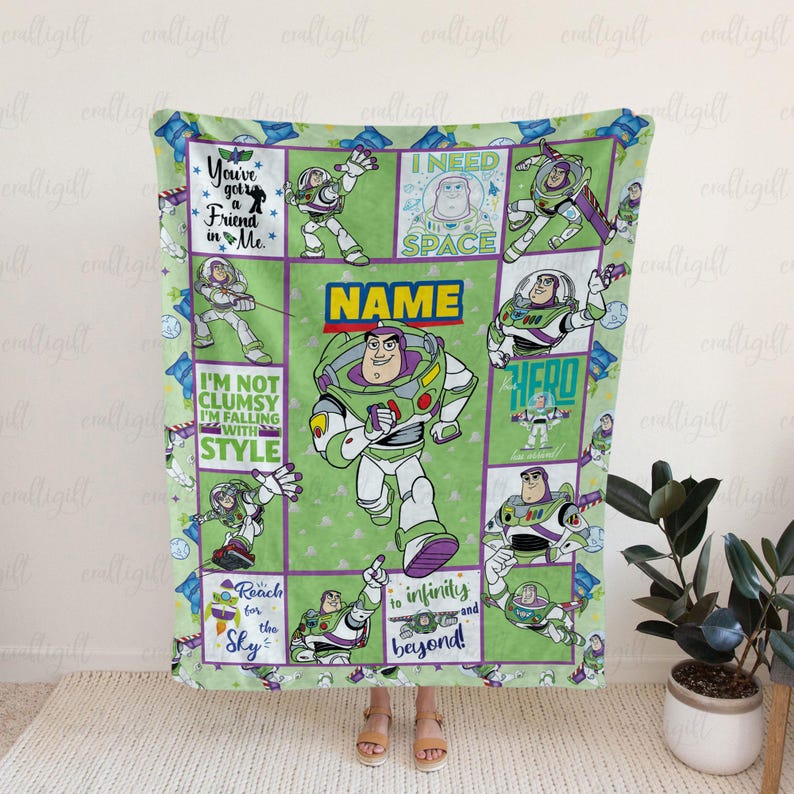 K&ouml;nnte beinhalten: Eine gr&uuml;ne Fleecedecke mit mehreren Feldern, die die Figur Buzz Lightyear in verschiedenen Posen zeigen. Die Decke enth&auml;lt Texte wie You've got a Friend in Me, I NEED SPACE, I'M NOT CLUMSY I'M FALLING WITH STYLE und Reach for infinity and beyond.