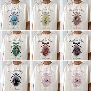 May include: Cream-colored t-shirts with the text "Happiest Mom on Earth" above a cartoon character portrait. Each shirt features a different character in a decorative frame with a bow.