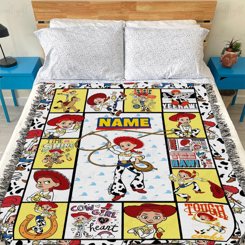 May include: A woven throw blanket featuring a grid of multiple illustrations of the character Jessie from Toy Story, including text such as NAME, YEE HAW, and COW GIRL AT HEART, with a cow print border and fringed edges on all sides.