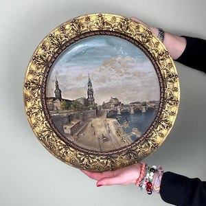 Könnte beinhalten: Ein Set aus drei Keramikbechern mit gesprenkelter, matter Oberfläche. Die Becher sind in Creme-, Hellgrau- und Dunkelgrautönen gehalten. Jeder Becher hat ein schlichtes, minimalistisches Design und einen abgerundeten Henkel. Für Kaffee oder Tee.