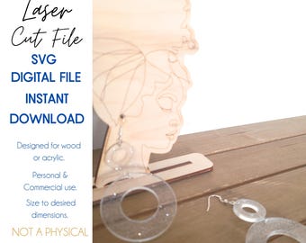 May include: Laser cut file SVG digital download for creating earrings. The design features a pair of large, clear, circular earrings with a smaller circle inside. The earrings are shown on a wooden stand with a laser cut design of a woman's face.