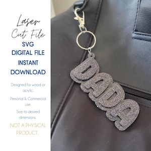 May include: A silver key chain with a glittery black "DADA" charm. The charm is attached to a black bag.