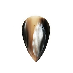 Puede incluir: Una púa de guitarra marrón y negra hecha de cuerno.