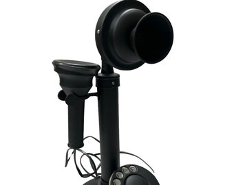May include: A black rotary dial phone with a black handset and a black base. The phone has a circular dial with white numbers and a black button in the center.