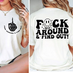 May include: White t-shirt with a black graphic on the front that says "F*ck Around & Find Out" with a skeleton middle finger. The back of the shirt has a black graphic that says "F*ck Around & Find Out!" with a dripping smiley face.