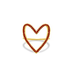 May include: A gold ring with a heart-shaped design. The heart is outlined with small red gemstones.