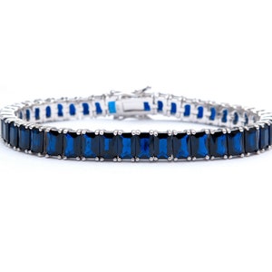May include: A silver tennis bracelet with a row of dark blue rectangular gemstones.