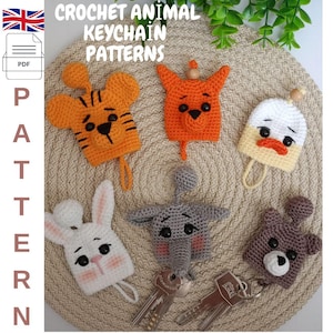 May include: A collection of crocheted animal keychain patterns. The keychains include a tiger, fox, duck, bunny, elephant, and bear. The keychains are in various colors, including orange, white, gray, and brown. The text "CROCHET ANIMAL KEYCHAIN PATTERNS" is visible.