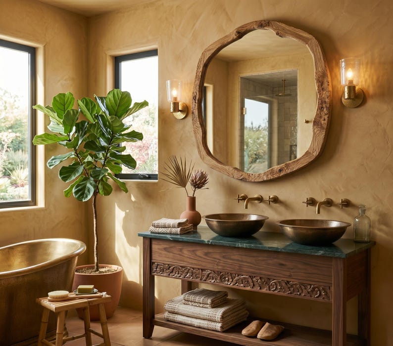 May include: A bathroom with a large, rustic wooden mirror. A dark wood vanity unit with two bronze sinks and a green countertop is below. A potted plant and a bronze bathtub are also visible.
