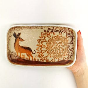 May include: A white ceramic rectangular serving tray with a brown deer and a brown mandala design.