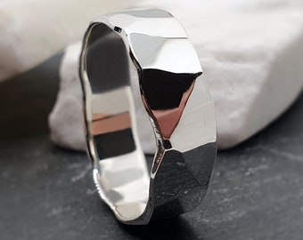 May include: A silver hammered band ring with a textured finish.