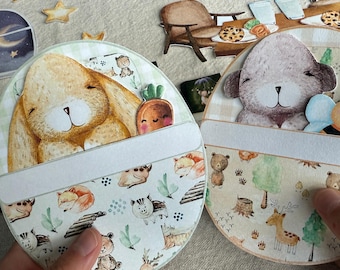 May include: Two round, illustrated cards featuring a bunny and a bear. The bunny card has a carrot, and the bear card has a bee. Both cards have a white space for text and are decorated with woodland animal and nature illustrations.