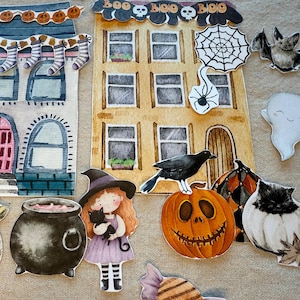 Könnte beinhalten: Aquarellillustrationen von Halloween-Themen-Ausschnitten. Enthält ein Spukhaus, eine Hexe, eine schwarze Katze, einen Kürbis, eine Fledermaus, einen Geist, einen Frosch, eine Spinne, einen Kessel und Süßigkeiten. Die Häuser haben den Text "BOO" und "BOO BOO".