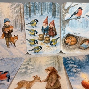 May include: A set of illustrated cards showing winter scenes. The cards feature children, animals, and gnomes in a snowy forest setting. The illustrations are in a watercolour style, with soft colours and detailed imagery.