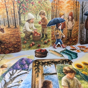 May include: A collection of illustrated seasonal cards featuring children and autumn scenes. The cards depict children picking apples, walking in the rain, and a squirrel on a tree. The word "Autumn", "September", "October", and "November" are visible.