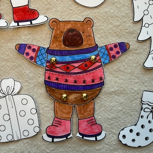 Puede incluir: Ilustraci&oacute;n de un oso pardo con un su&eacute;ter colorido y patines. El oso tiene una nariz marr&oacute;n oscuro y est&aacute; rodeado de otros recortes tem&aacute;ticos navide&ntilde;os, incluyendo un regalo, un calcet&iacute;n y un &aacute;rbol de Navidad.