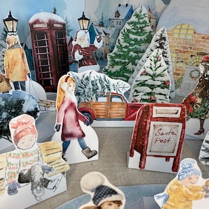 May include: Watercolor illustration of a winter village scene with cut-out figures. Includes a red telephone booth, Santa Claus, Christmas trees, and children. A red mailbox reads "Santa Post".
