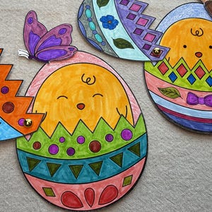 Op de afbeelding: Handgetekende paasei-decoraties in levendige kleuren. De eieren zijn versierd met verschillende patronen, waaronder sterren, diamanten en bloemmotieven. Eén ei heeft een paarse vlinder. De eieren zijn in tinten oranje, blauw, groen, roze en paars.