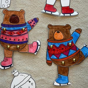 Puede incluir: Llaveros con forma de oso dibujados a mano con tem&aacute;tica invernal. Los osos visten jers&eacute;is coloridos y patines de hielo. Cada oso tiene ganchos dorados para llaves. Otros recortes con tem&aacute;tica invernal est&aacute;n en el fondo.