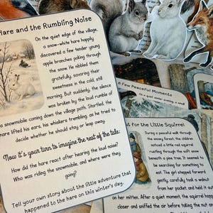 May include: A hand holds a card titled "The Hare and the Rumbling Noise" with a winter scene illustration. Other cards with animal illustrations and text are visible, suggesting a children's storybook theme.