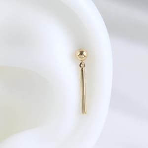 Orecchino a barretta pendente in oro massiccio 14 carati, piercing a perno senza filettatura con pallina in oro vero, piercing leggero a pressione per elica, cartilagine e lobo dell'orecchio.