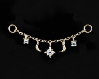 May include: A gold chain with small crescent moons and star charms, each with a clear crystal stone.