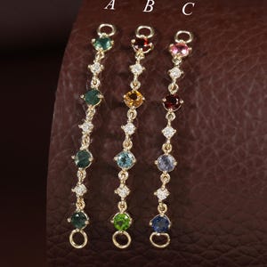 May include: Three gold-toned jewelry connectors labeled A, B, and C, each featuring a vertical chain of alternating small clear stones and larger round-cut colored gemstones in various hues including green, yellow, blue, red, and pink.