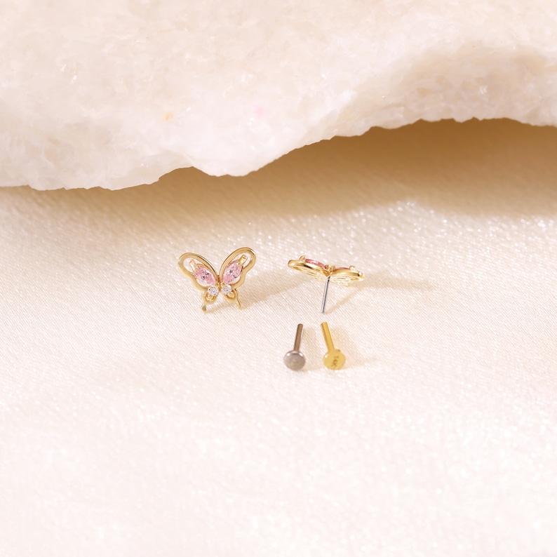 May include: A pair of gold butterfly earrings with pink and clear rhinestones. The earrings come with two different post styles.