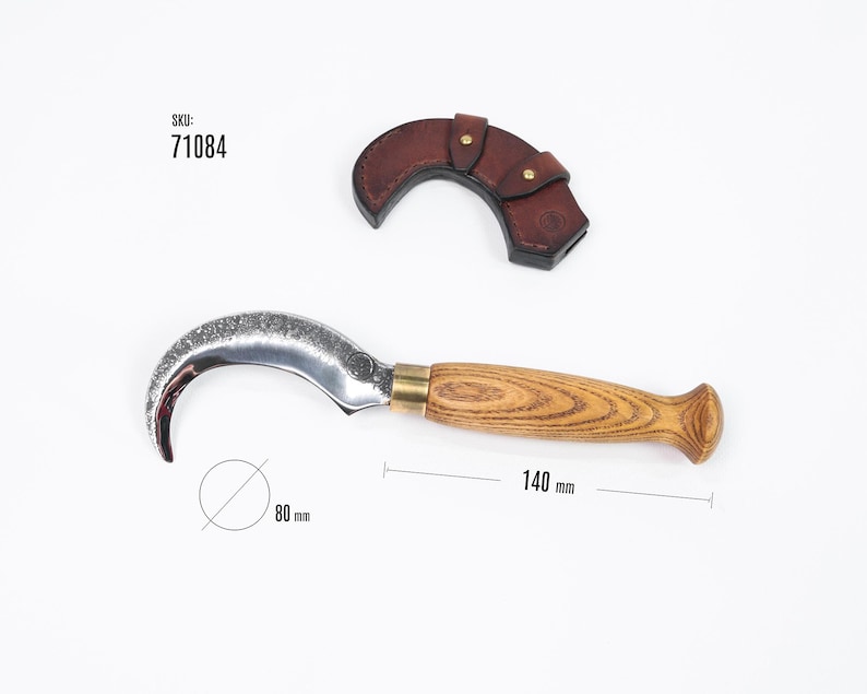 Puede incluir: Una hoja curva plateada con mango de madera y detalles en lat&oacute;n. La hoja tiene 80 mm de di&aacute;metro y el mango 140 mm de largo. Incluye una funda de cuero marr&oacute;n. SKU: 71084.