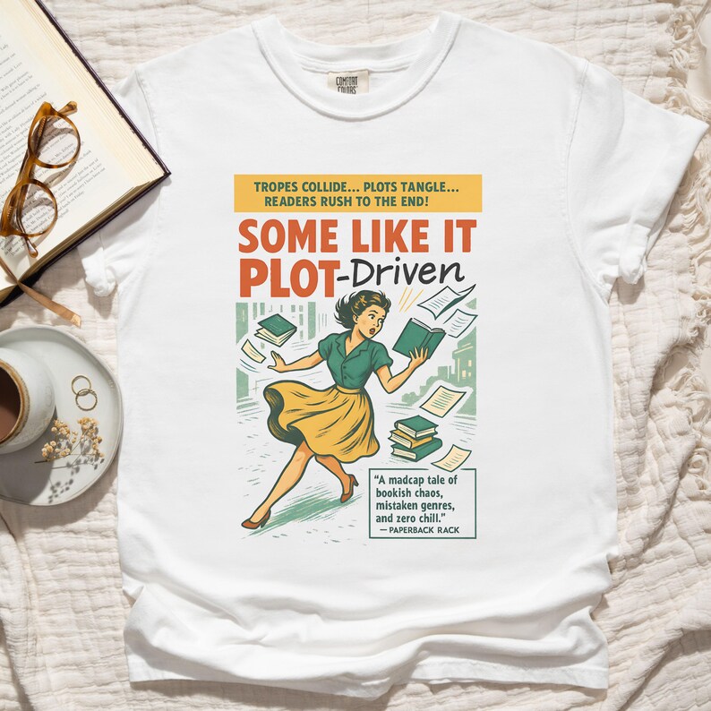 May include: White t-shirt with a retro graphic of a woman and books, with the text "SOME LIKE IT PLOT-Driven". The design includes the text "TROPES COLLIDE... PLOTS TANGLE... READERS RUSH TO THE END!" and a quote. The t-shirt is a comfortable fit.