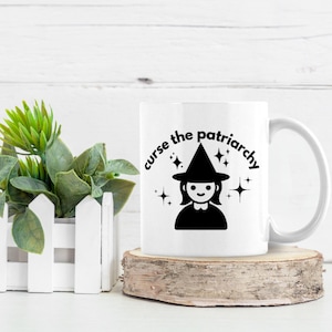 May include: White ceramic mug with a black and white illustration of a witch with the text "curse the patriarchy" around her.