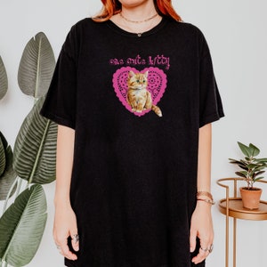 Op de afbeelding: Zwart oversized T-shirt met een roze hart en een schattig kitten erin. De tekst "one cute kitty" staat boven het hart gedrukt.