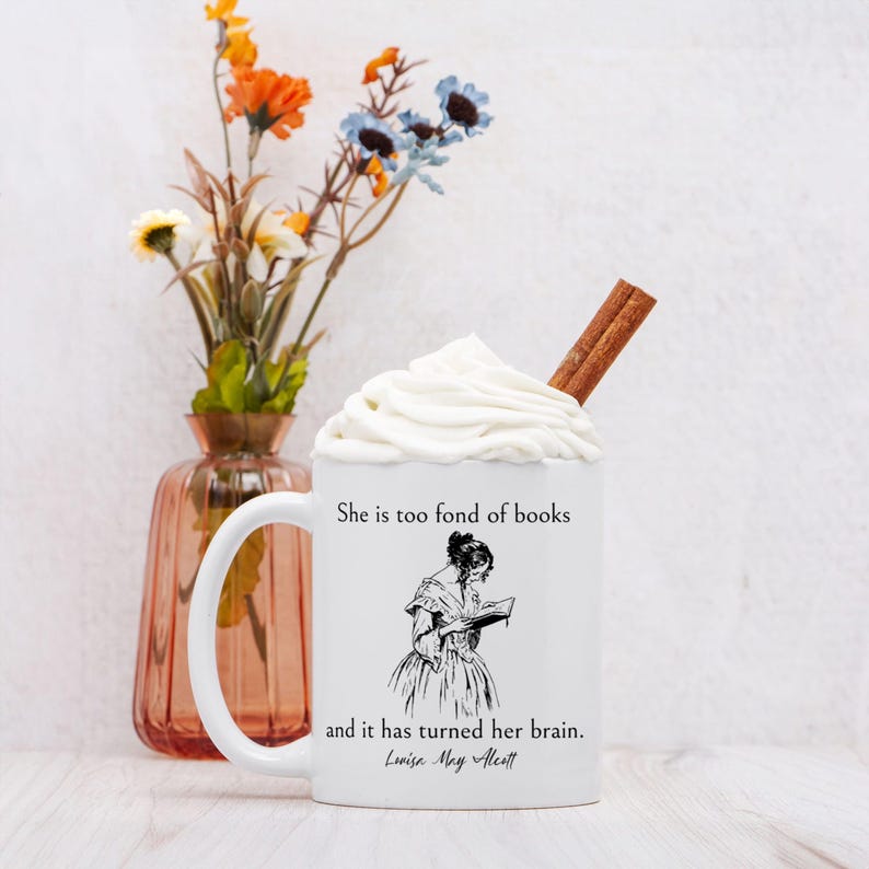 May include: White ceramic mug with a black and white illustration of a woman reading a book. The mug has the text "She is too fond of books and it has turned her brain. Louisa May Alcott" printed on it.