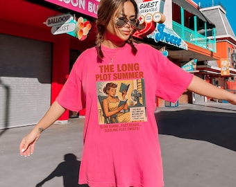 May include: A bright pink t-shirt with the text "THE LONG PLOT SUMMER" and an illustration of a woman reading. The graphic also includes the text "SLOW BURNS... FAST READS... SIZZLING PLOT TWISTS!"