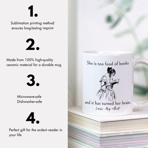 May include: White ceramic mug with a black and white illustration of a woman reading a book. The mug has the text "She is too fond of books and it has turned her brain. Louisa May Alcott" printed on it. The mug is sitting on a stack of books.