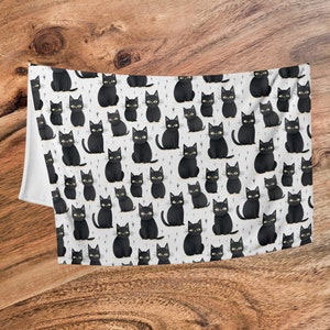 May include: A white background with a repeating pattern of black cats. The cats are all facing forward with their tails curled behind them. They have yellow eyes and are sitting in a variety of poses.